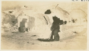 Image of Snow house and small boy with small sledge